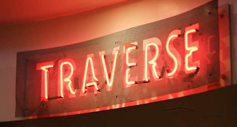Red neon sign reading 'TRAVERSE'.