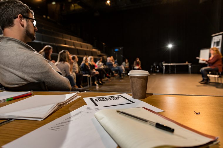 A workshop in our large Traverse 1 performance space. A note book is lying open on a table.